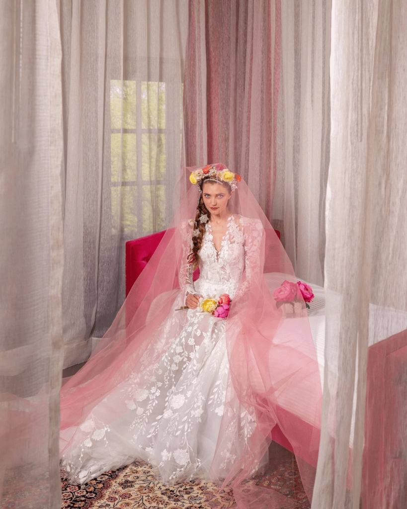 A white dress with a pink veil and bright bouquet
